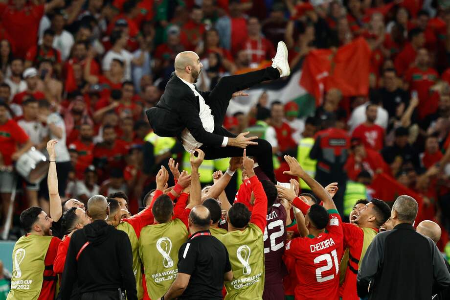 Los jugadores de Marruecos celebran con su entrenador.