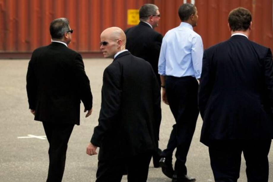 Los hombres de seguridad del presidente Barack Obama lo rodean durante una visita que realiza a Tampa, Florida. / AFP