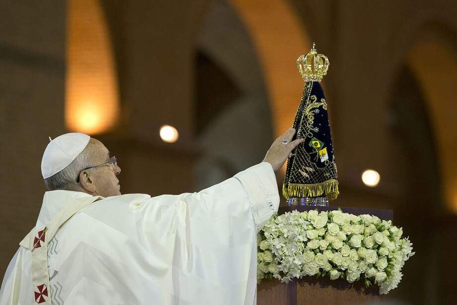 El sumo pontífice toca la estatuilla de la Virgen de Nuestra Señora de Aparecida, una de las más populares de Brasil. / EFE