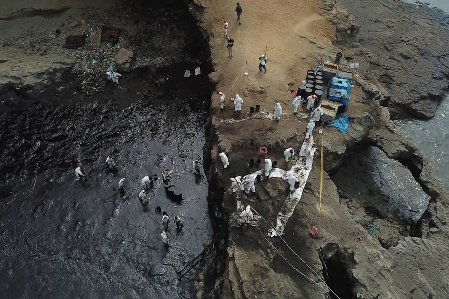 Vista aérea de brigadas de limpieza ayudando a recoger el crudo de una playa al norte de Lima.