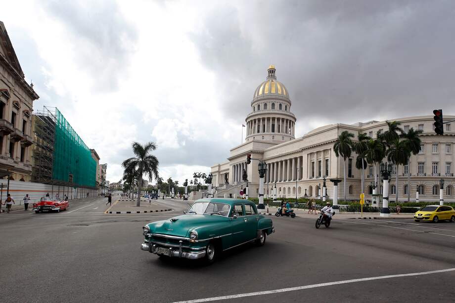 Fotografía de un auto clásico mientras cruza frente al Capitolio cubano en La Habana (Cuba). EFE/ Ernesto Mastrascusa