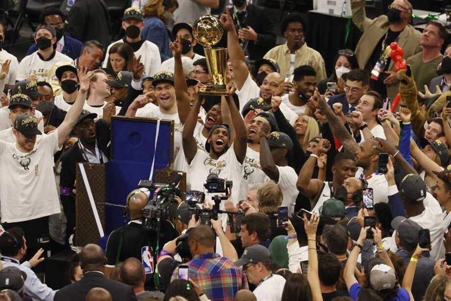 Khris Middleton levanta el trofeo del campeonato de la NBA.