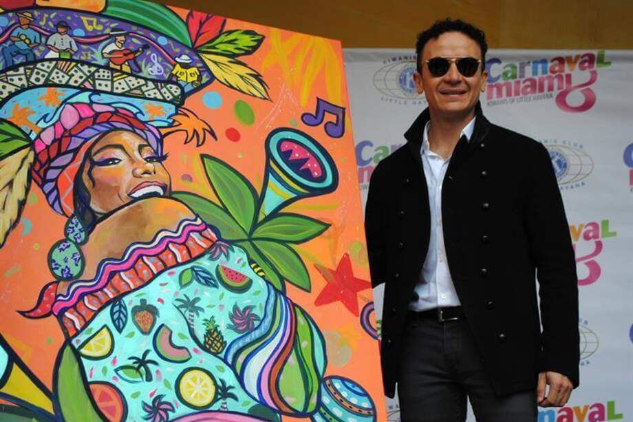 Fonseca posa con el cartel del Carnaval de la Calle Ocho de Miami, diseñado por la artista ecuatoriana Alejandra Estefanía, durante la presentación del evento en Miami, Florida (EE.UU.). / EFE