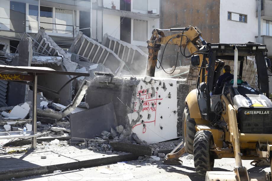 Fotografía que muestra una retroexcavadora trabajando frente a una edificación destruida por un terremoto de magnitud 7,4 este lunes, en Manizales (Colombia).