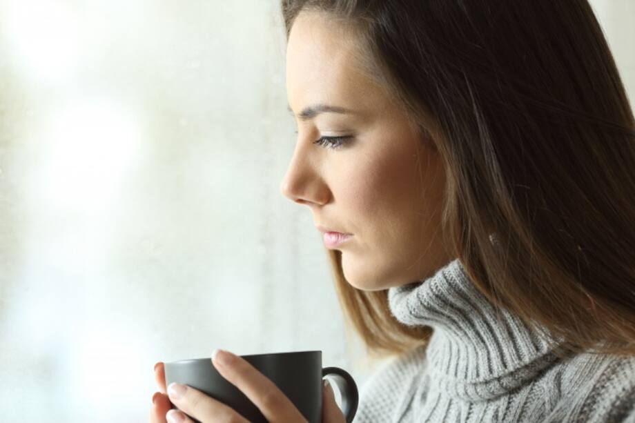 mujer sosteniendo una tasa de café