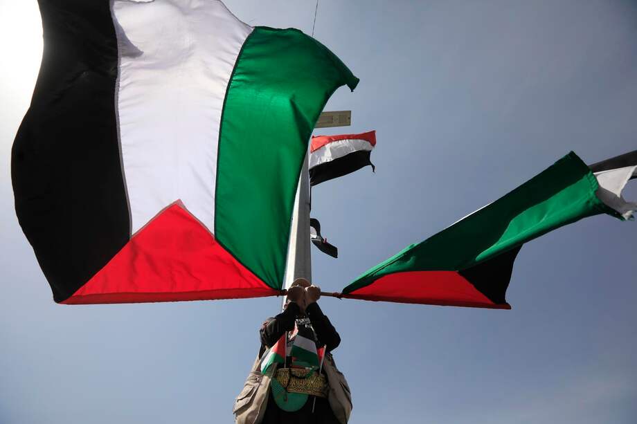 Un partidario hutí ondea banderas palestinas durante una protesta contra Estados Unidos y Israel en Saná, Yemen, el 23 de mayo de 2025.