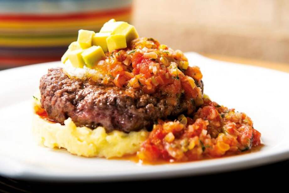 Hamburguesa sobre puré de papa y arracacha con salsa criolla