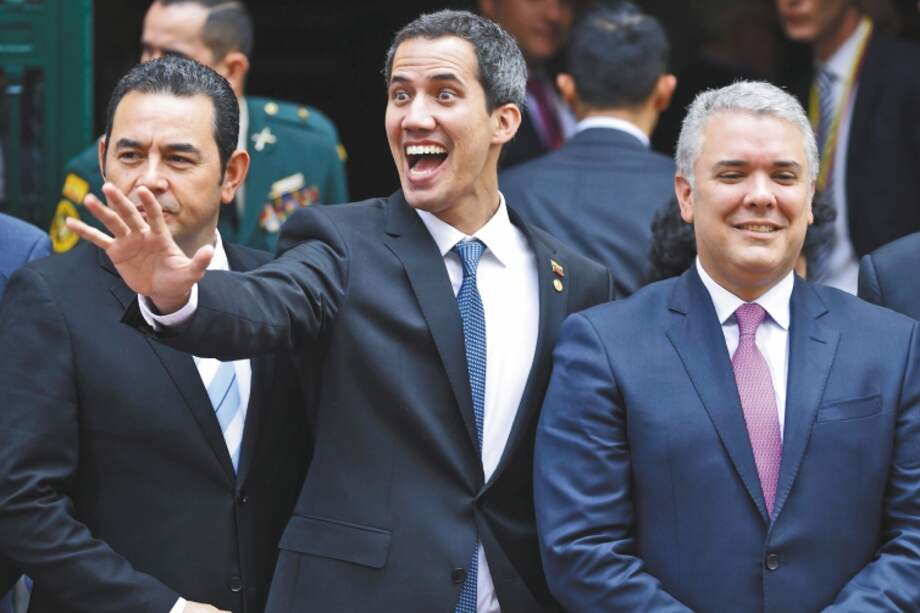 Venezuela's self-proclaimed interim president Juan Guaido waves alongside, from left, Guatemala's President Jimmy Morales, Colombia's President Ivan Duque and Panama's President Juan Carlos Varela as they gather for a group photo after attending an emergency Lima Group meeting concerning Venezuela, in Bogota, Colombia, Monday, Feb. 25, 2019. As it struggles to find new ways to boost Guaido after an effort to deliver humanitarian aid to the economically devastated nation faltered amid strong resistance from security forces who remain loyal to Venezuela's President Nicolas Maduro, the Trump administration announced new sanctions on Maduro's allies. (AP Photo/Martin Mejia)