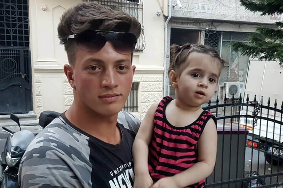 Faouzi Zabaat, un argelino de 17 años, posa con la pequeña Doha Mohammed. / AFP