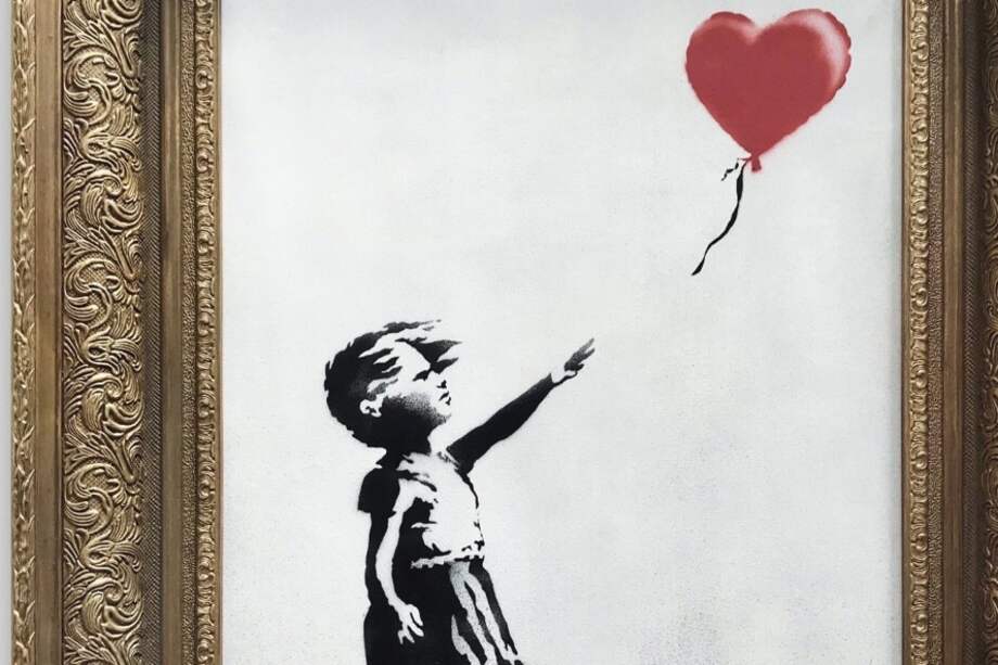 La obra "Niña con globo", en acrílico y aerosol, ahora una de las más famosas de Banksy, muestra a una niña que deja partir al aire su globo rojo en forma de corazón. / Cortesía