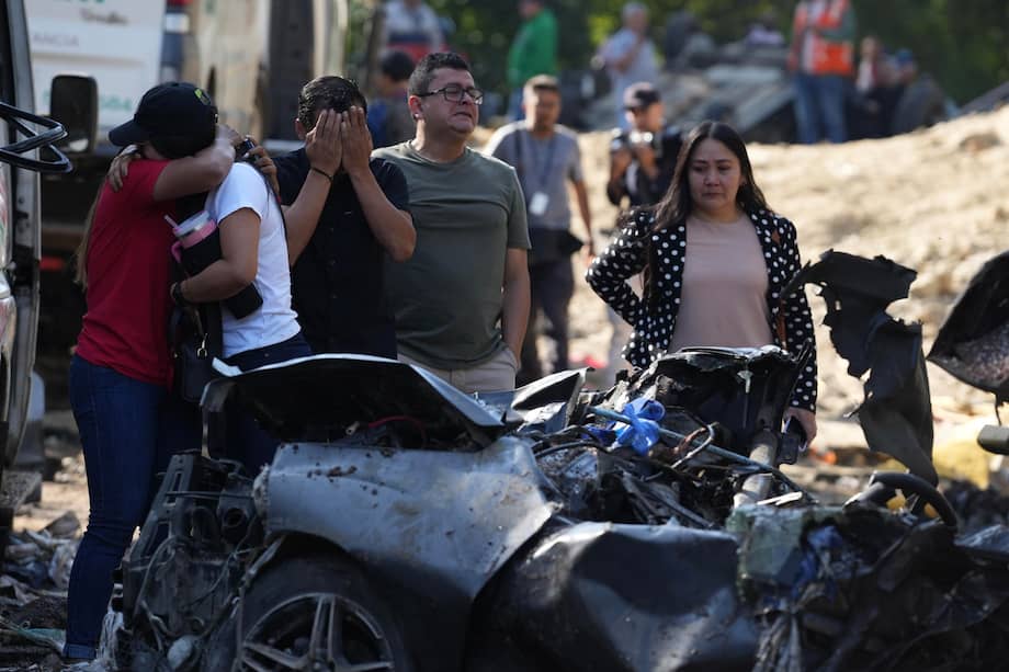 Familiares de las víctimas del atentado ocurrido en la Vía Panamericana lloran este domingo frente a los escombros de los vehículos destruidos en Cajibío (Colombia). La explosión de un cilindro bomba lanzado el sábado por presuntos disidentes de las FARC en un tramo de la Vía Panamericana, en el departamento colombiano del Cauca (suroeste), dejó 19 muertos, cinco más de los informados la víspera, señalaron este domingo las autoridades. EFE/Ernesto Guzmán