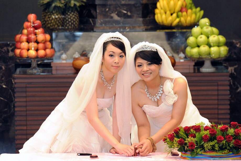 Fish Huang y You Ya-ting acudieron a la ceremonia con los tradicionales vestidos blancos de boda. / Afp