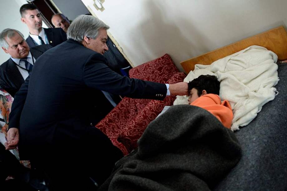 El alto comisionado de la ONU para los Refugiados (ACNUR), Antonio Guterres, revisa el estado de un niño sirio enfermo durante su visita al campamento de refugiados.