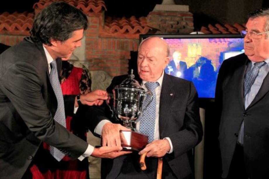 El presidente del Millonarios, Felipe Gaitán (i) entrega un trofeo conmemorativo al exfutbolista argentino Alfredo Di Stefano (c), presidente de honor del Real Madrid. / EFE