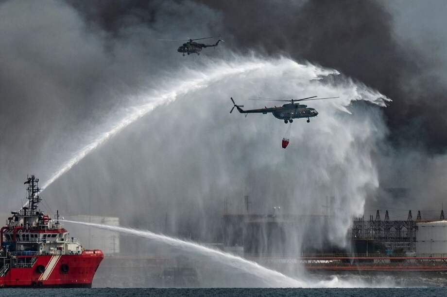 El buque de extinción de incendios mexicano "Bourbon Artabaze" y varios helicópteros luchan para contener el incendio en un depósito de combustible en Matanzas, Cuba.
