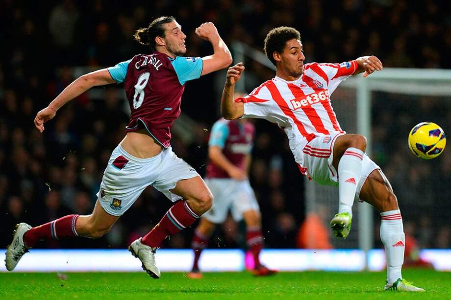 Ryan Shotton de Stoke City rechaza el balón ante el acoso de Andy Carroll del West Ham. / AFP