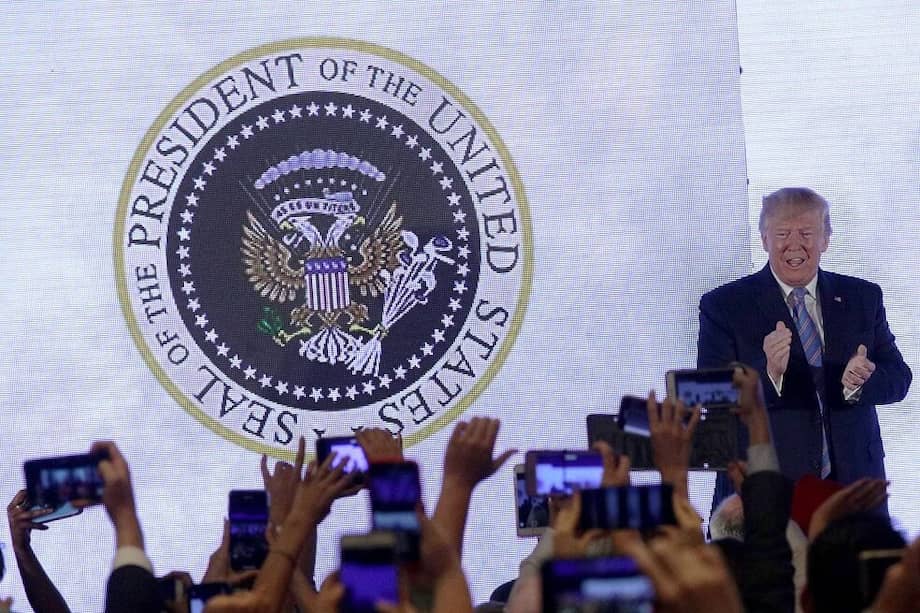 El Presidente de Estados Unidos, Donald Trump, dio un discurso con la proyección a su espalda de un escudo que se burlaba de él. / AFP