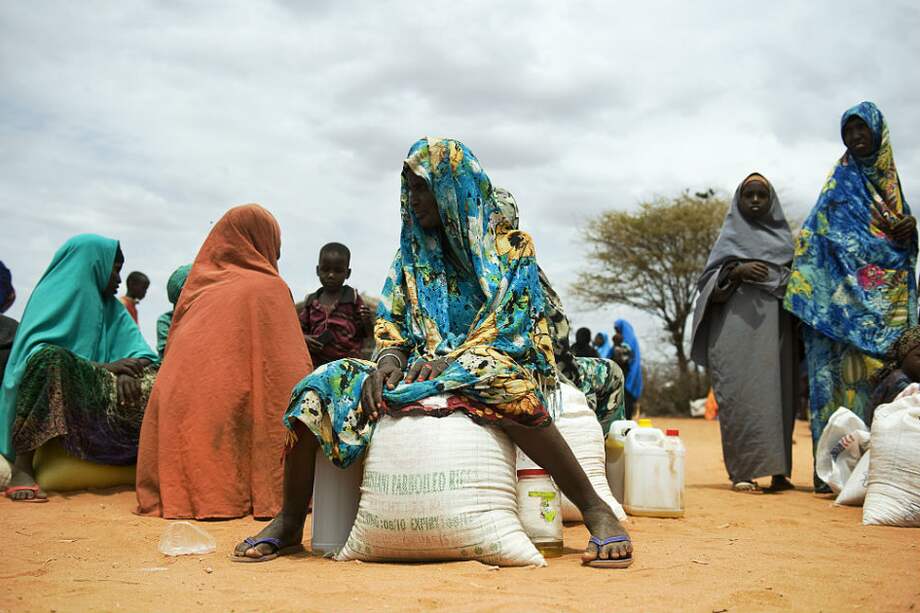 Mujeres somalíes que se sientan con sus raciones de alimentos de socorro después de recibirlas durante un ejercicio de distribución en un campo de desplazados en Dollow.
