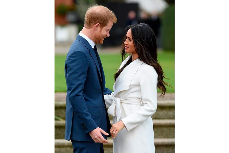 El príncipe Enrique de Inglaterra y su prometida, la actriz estadounidense Meghan Markle, posan para los fotógrafos en los jardines del palacio de Kensington, donde reside el nieto de la reina Isabel II. / EFE
