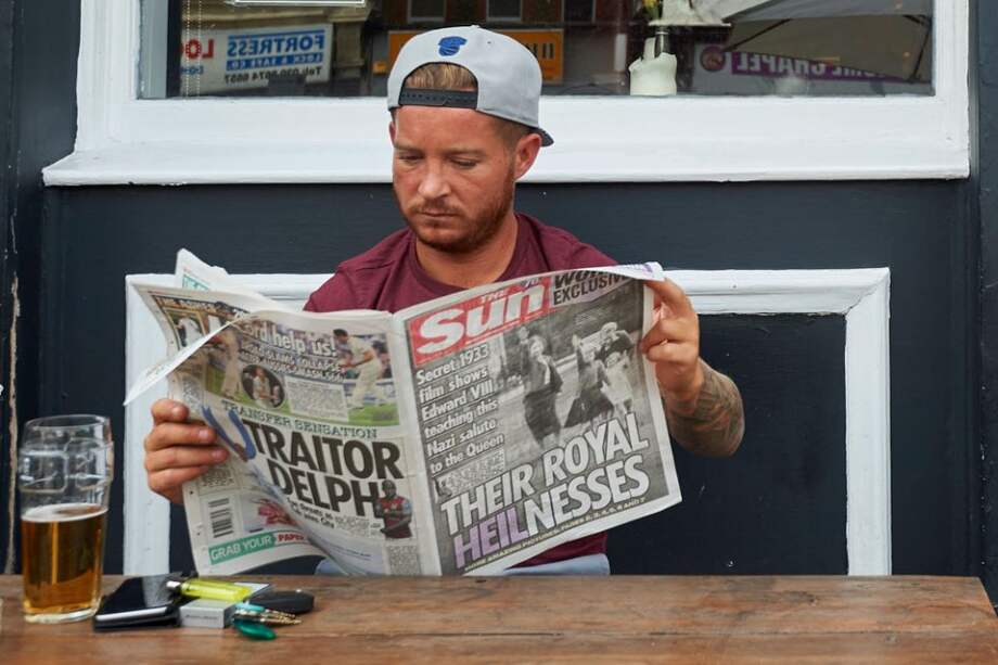 Un hombre lee un ejemplar de The Sun. / AFP