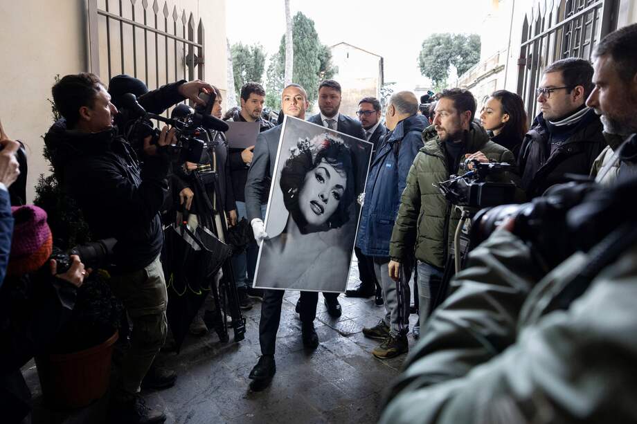 Un hombre lleva una foto de la difunta actriz italiana Gina Lollobrigida en su juventud para ser instalada en el Aula Giulio Cesare en la Colina Capitolina (Campidoglio) en Roma, Italia, el 18 de enero de 2023. Lollobrigida, una actriz europea de alto perfil en la década de 1950 y principios de la década de 1960, murió el 16 de enero a los 95 años.