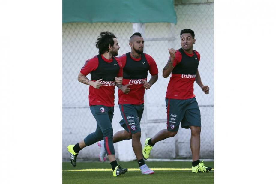 Arturo Vidal (c) junto a sus compañeros Jorge Valdivia (i) y Gonzalo Jara (d) en el entrenamiento de este lunes con la selección chilena / EFE