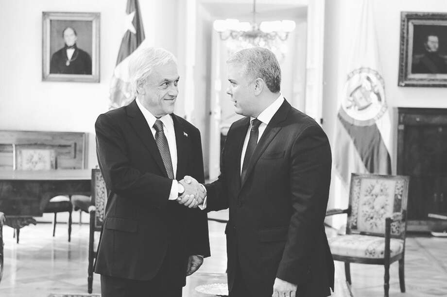 El expresidente Iván Duque (d) lamentó la el fallecimiento del expresidente chileno Sebastián Piñera (i).