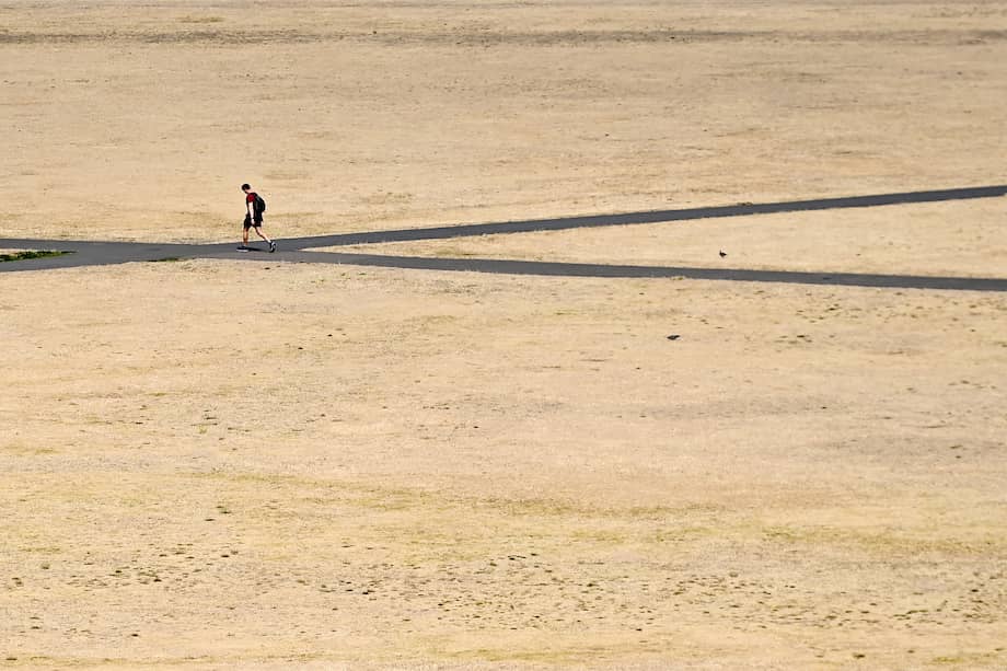 Un hombre camina por las tierras de pasto resecas de Greenwich Park en Londres, Gran Bretaña. El país afronta su verano más seco desde 1976.