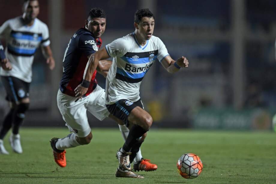El jugador de San Lorenzo Nestor Ortigoza (i) disputa el balón con Giuliano (d) de Gremio. / EFE
