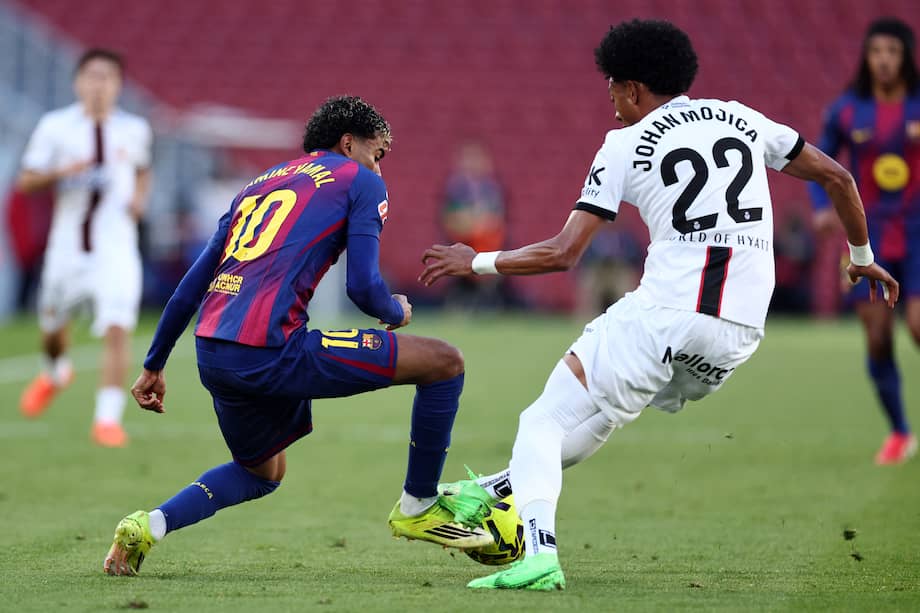 Lamine Yamal disputa un balón con Johan Mojica.