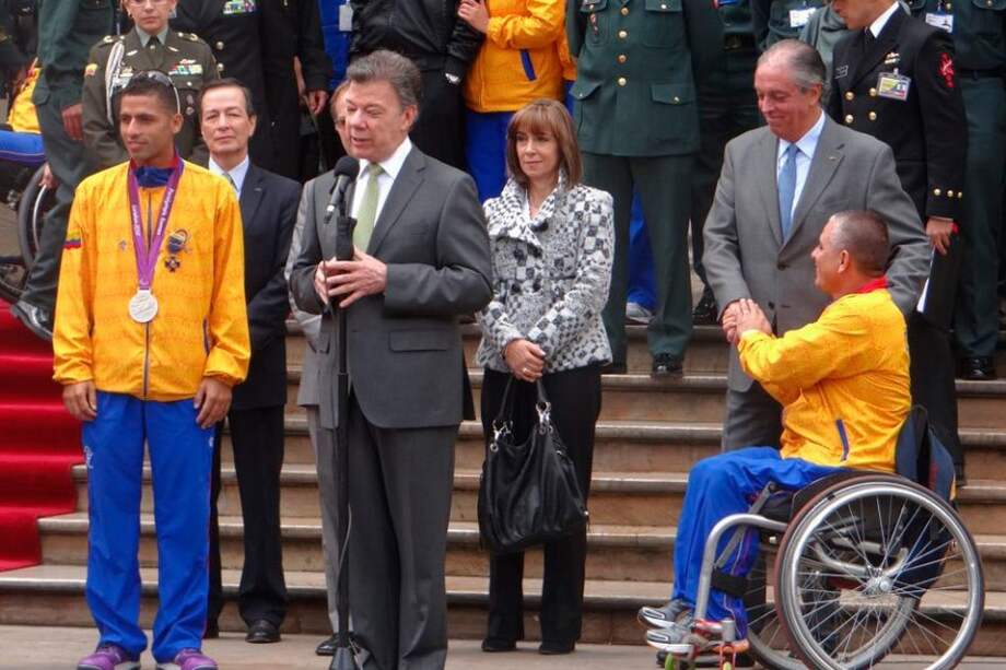 Juan Manuel Santos y los deportistas paralímpicos Moisés Fuentes (d) y Elkin Serna (i). / Cortesía Coldeportes