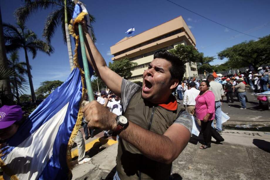 Un hombre con una bandera se manifiesta contra la propuesta sandinista de reformar la Constitución./ EFE