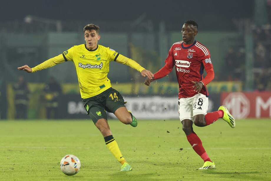 El defensa de Defensa y Justicia Ezequiel Cannavo (izq.) y el delantero de Independiente Medellín Mender García luchan por el balón durante el partido de fútbol de vuelta de la fase de grupos de la Copa Sudamericana.