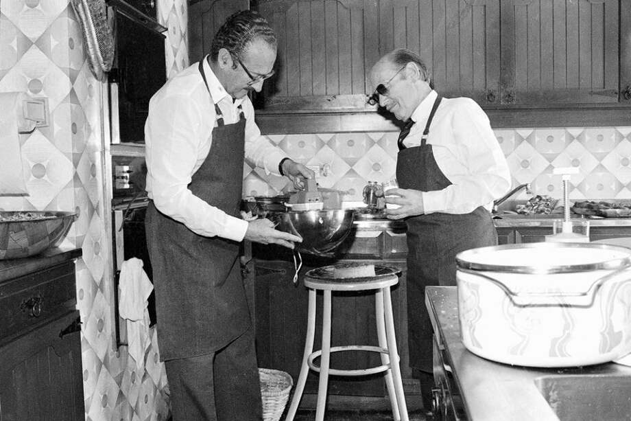 Fernando Londoño Henao (izq.) durante un almuerzo de amigos en su casa campestre en 1981, haciendo gala de su talento culinario. / Archivo - El Espectador
