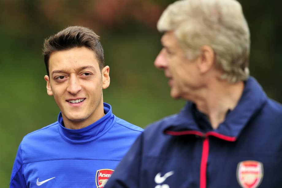 El volante estrella del Arsenal, Mesut Özil, y el DT francés Arsene Wenger. / AFP