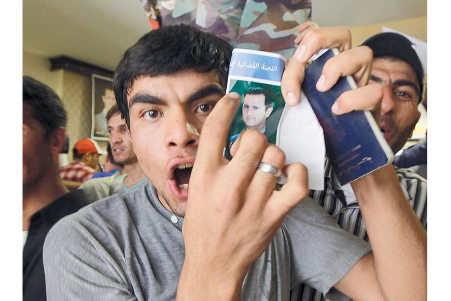 Un ciudadano sirio residente en el Líbano muestra una fotografía del presidente sirio Bashar al Asad, luego de votar en Beirut. / EFE