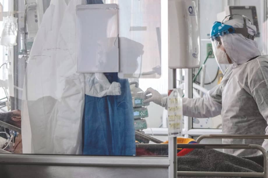 TOPSHOT - Health personnel wearing a protective suits against the spread of the COVID-19 assist a patient at the intensive care unit in El Tunal Public Hospital, Bogota, on June 16, 2020.
Bogota's Mayor, Claudia Lopez, declared on Sunday the orange alert in the capital of Colombia, due to the occupation of 54% of the intensive care units (ICU) amid the new coronavirus pandemic. / AFP / Juan BARRETO