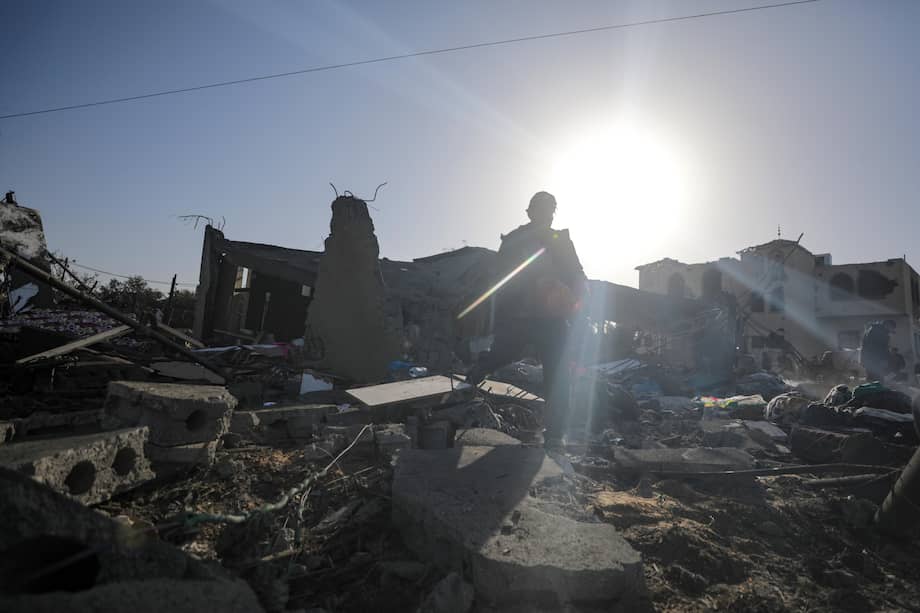 Palestinos buscan cadáveres y sobrevivientes entre los escombros, tras un ataque aéreo israelí en Deir Al Balah, al sur de la Franja de Gaza.