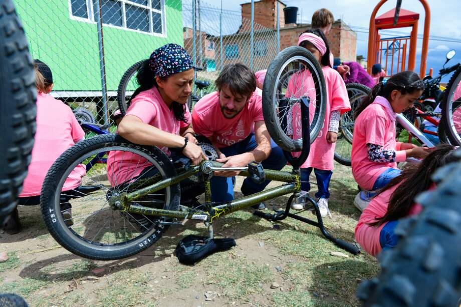 Voluntarios de la Fundación Niñas Sin Miedo arreglan bicicletas para realizar actividades en el barrio Los Pinos, Soacha. / David Schwarz