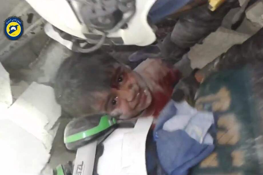 Un niño es rescatado de los escombros tras un bombardeo en Alepo. / AFP