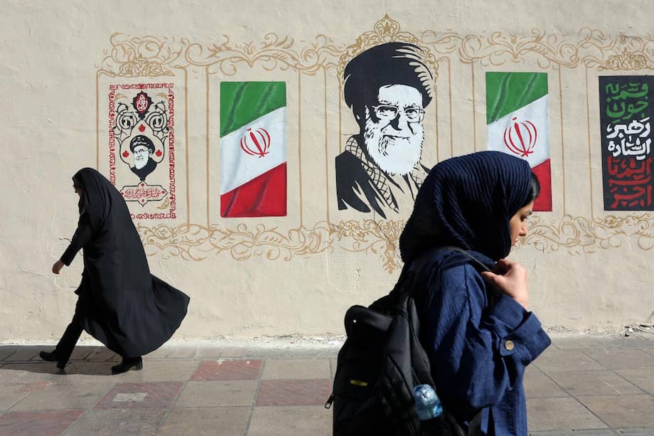 Mujeres iraníes caminan junto a un mural del difunto Líder Supremo iraní, el ayatolá Ali Jamenei.