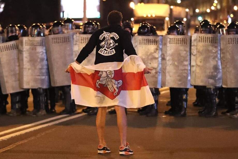Un manifestante se enfrenta a la policía antidisturbios durante una protesta en Bielorrusia contra la victoria de Alexander Lukashenko en los comicios presidenciales.