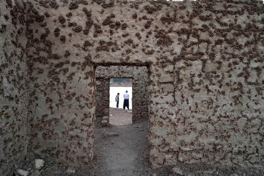 La gente visita los restos de la aldea sumergida de Gary Qasruka abandonada hace 36 años, que han resurgido después de una gran caída en el nivel del agua.