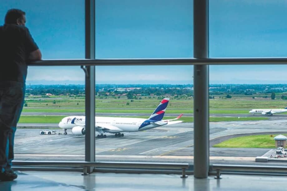 Vista de un avión de la aerolínea Latam desde el interior de un aeropuerto.
