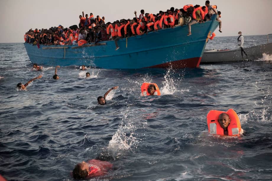 Migrantes, en su mayoría de Eritrea, saltan de un bote en el Mediterráneo en busca de ayuda (agosto de este año). / AP
