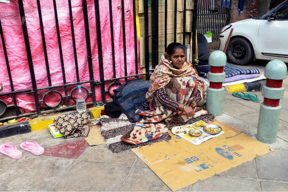 Krishna, una mujer sin hogar enferma de lepra, almuerza en una calle de Nueva Delhi, India, mientras espera recibir ayuda de los transeúntes en uno de los inviernos más fríos de la historia de la capital. / EFE