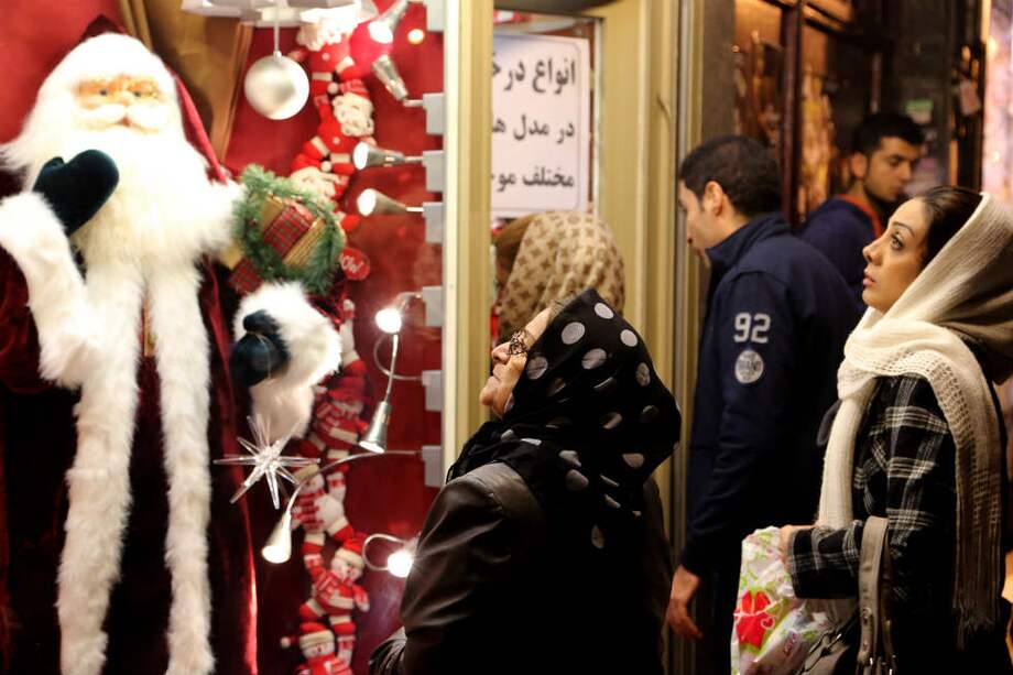 Mujeres iraníes observan una vitrina en la capital, Teherán, en donde se despliegan ornamentos para la Navidad. / AFP