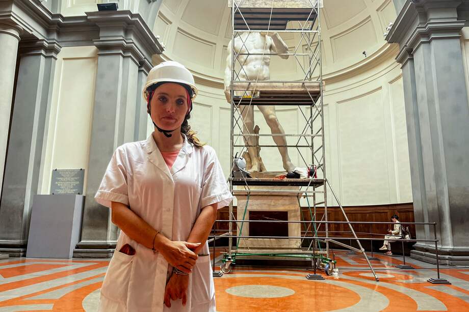 La restauradora Eleonora Pucci posa delante del "David" de Miguel Ángel en la Galería de la Academia en Florencia, Italia. Pucci se sube cada dos meses hasta la cabeza de la estatua para limpiarle el polvo.