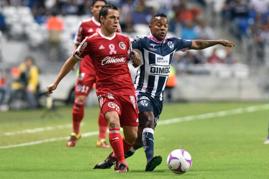 El colombiano Dorlán Pabón de Monterrey disputa una pelota con Juan Núñez en el partido frente a Tijuana en el que convirtió dos goles. / EFE