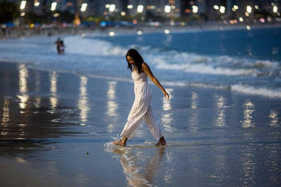 Una mujer camina por la orilla de la playa de Copacabana durante la celebración del Año Nuevo, en Río de Janeiro, Brasil.